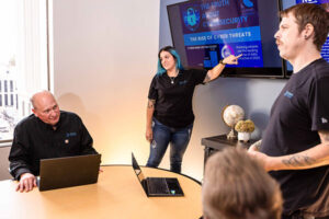 eCreek IT team presenting a cybersecurity threat report during a team training session, highlighting phishing attacks and rising cybercrime risks.